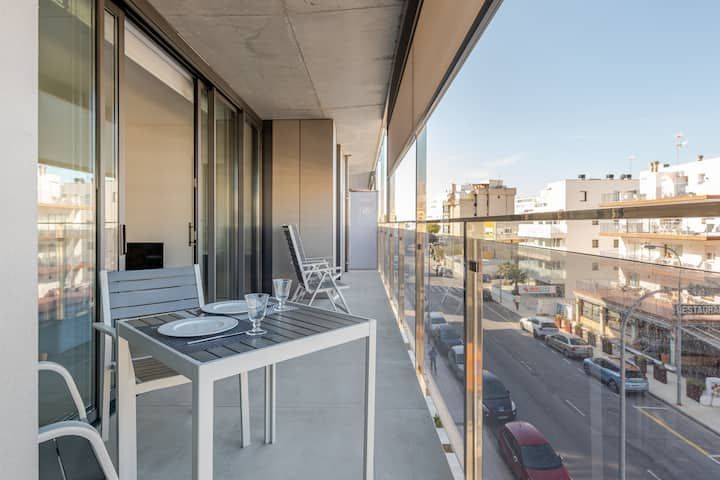 Un balcón con mesa y sillas y vista a la ciudad.