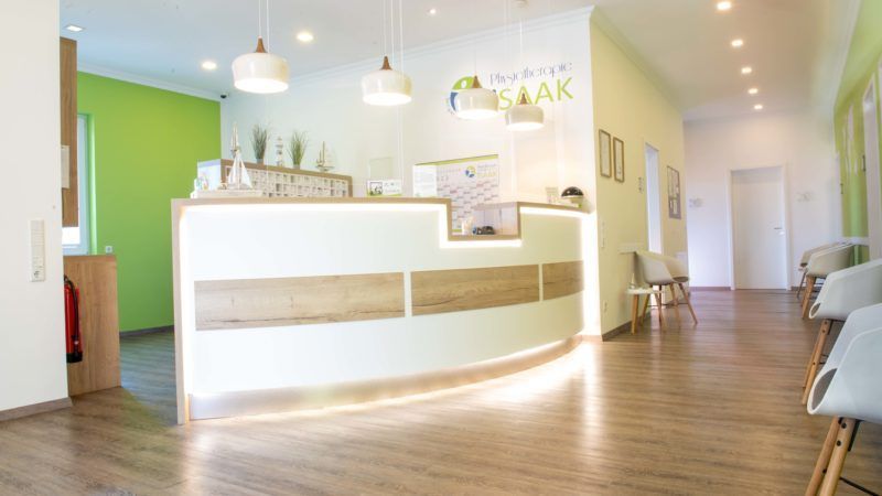 Ein Wartezimmer mit Empfangstresen und Stühlen.