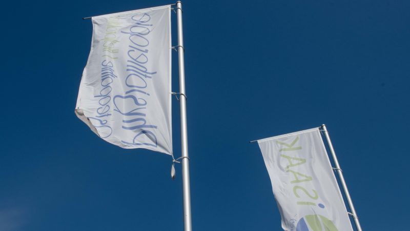 Zwei Flaggen wehen im Wind und auf einer steht „Maart“.