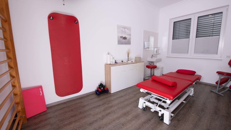 Ein Zimmer mit einem roten Bett und einer roten Matte an der Wand