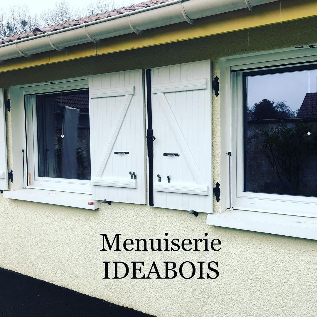 Volets blancs sur un bâtiment clair.