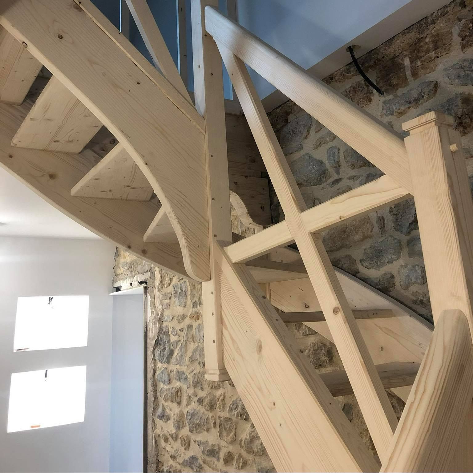 Escalier tournant en bois avec des rampes et des garde-corps