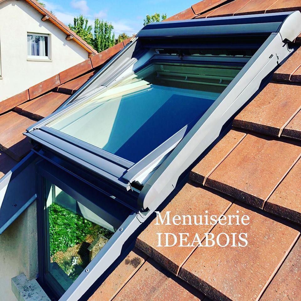 Puits de lumière sur un toit de tuiles avec fenêtre ouverte, cadre gris. 