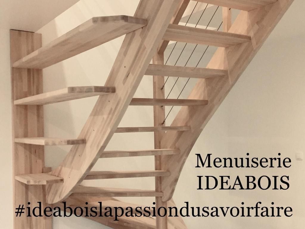 Escalier en bois avec étagères intégrées au mur. Les marches sont courbes. 