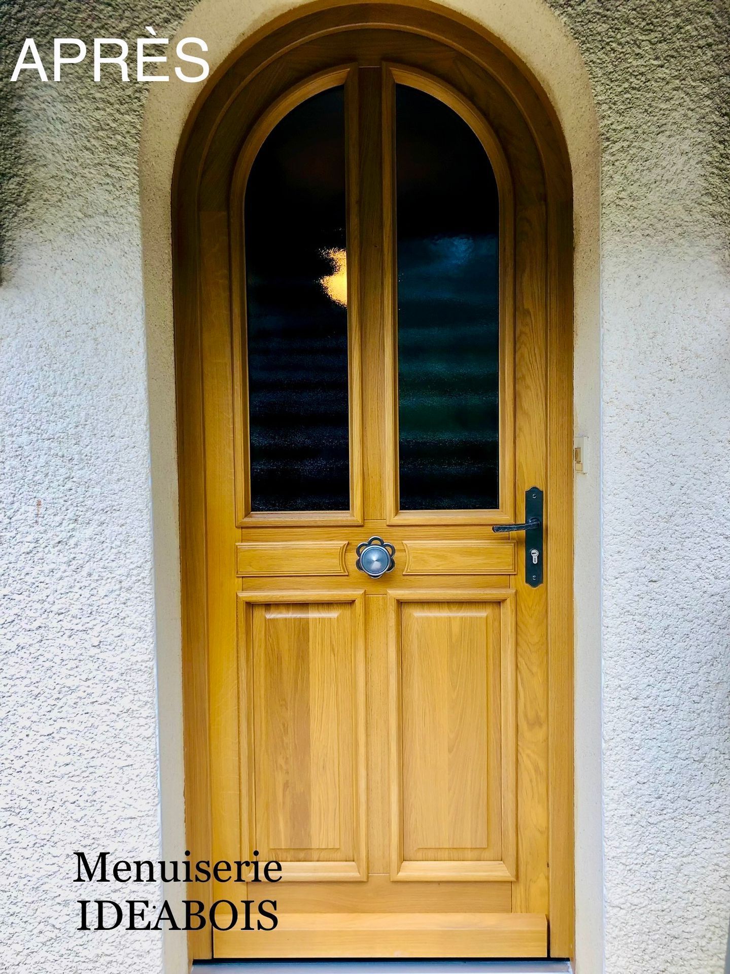 Porte en bois à arc surbaissé et panneaux de verre, installée sur un bâtiment de couleur neutre. 
