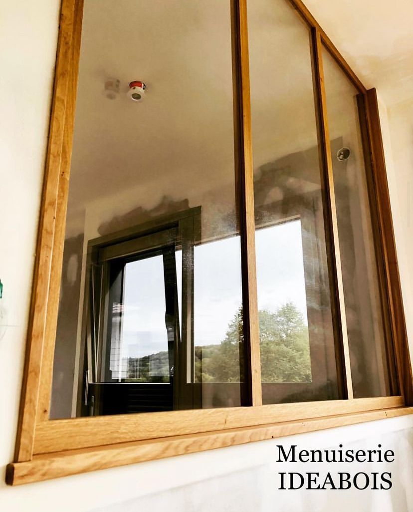 Fenêtre à cadre en bois avec trois vitres, reflétant l'espace intérieur et la vue extérieure