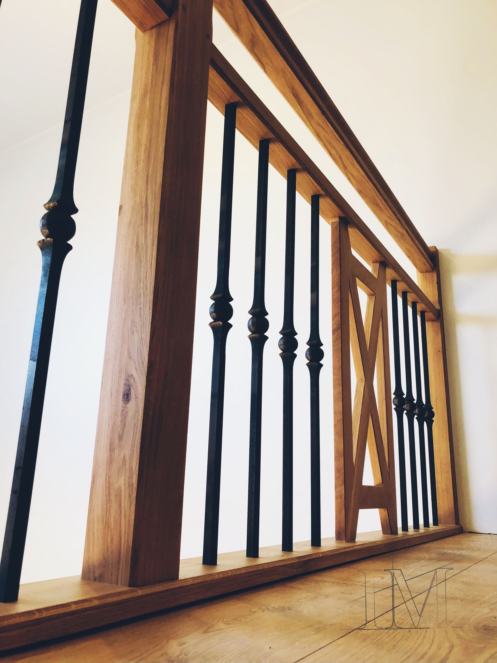 Rambarde en bois avec barreaux en fer noir, vue d'en bas.