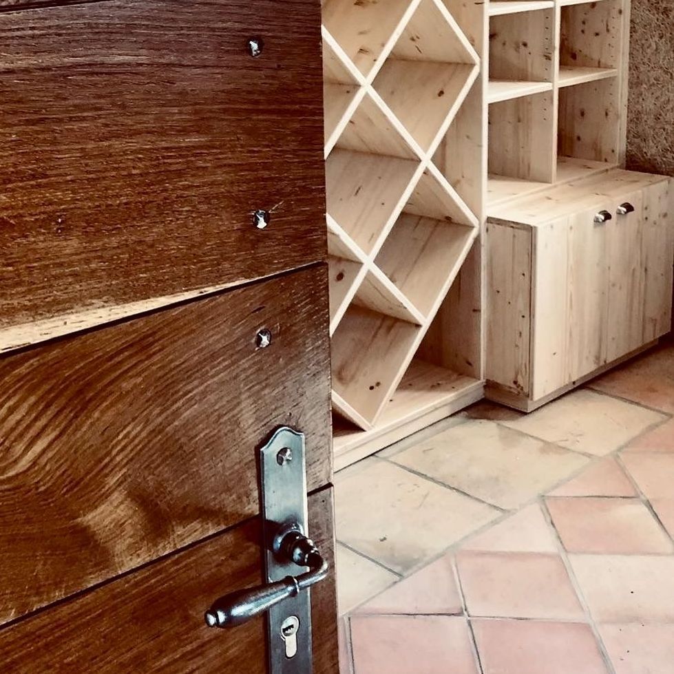 Une porte en bois avec un casier à vin en bois en arrière-plan