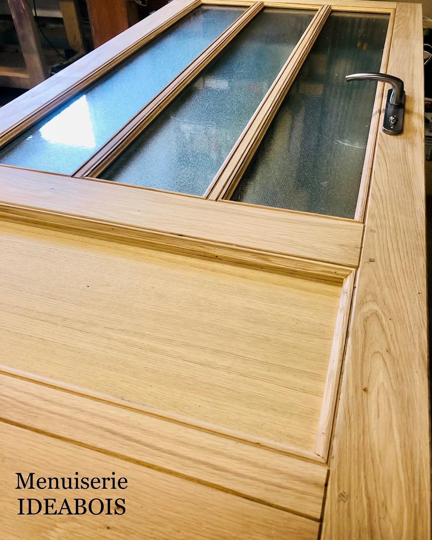 Porte en bois à panneaux de verre ; poignée à droite. 