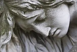 Un primer plano de una estatua de una mujer con los ojos cerrados.