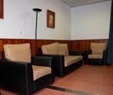 Una sala de estar con un sofá y dos sillas.