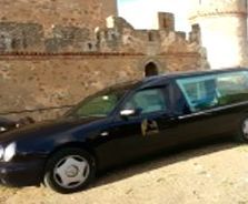 Un coche negro está aparcado delante de un castillo.