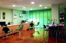 Una sala grande con pisos de madera, mesas y sillas.