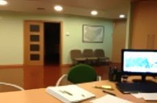 Un monitor de computadora está sobre un escritorio en una sala de espera.