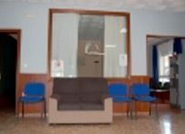 Una sala de estar con un sofá, sillas y un espejo.