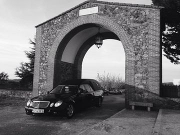 Un coche negro está aparcado bajo un arco de piedra.