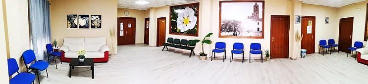 Un pasillo largo con muchas sillas y un sofá.