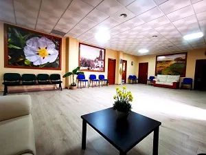 Una sala de estar con una mesa y sillas y un cuadro de una flor en la pared.