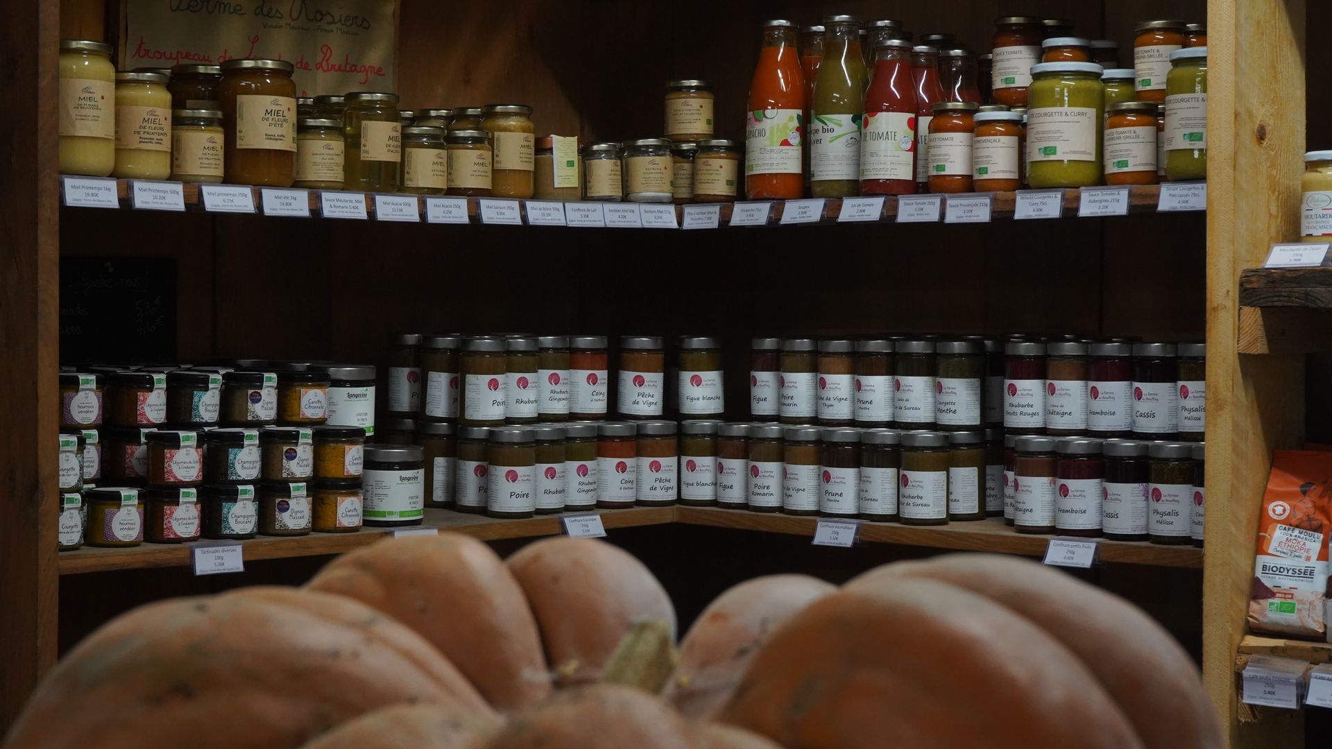 Panier de produits frais, comprenant des carottes, des pommes, du chou-fleur et des champignons, sur une surface en bois.