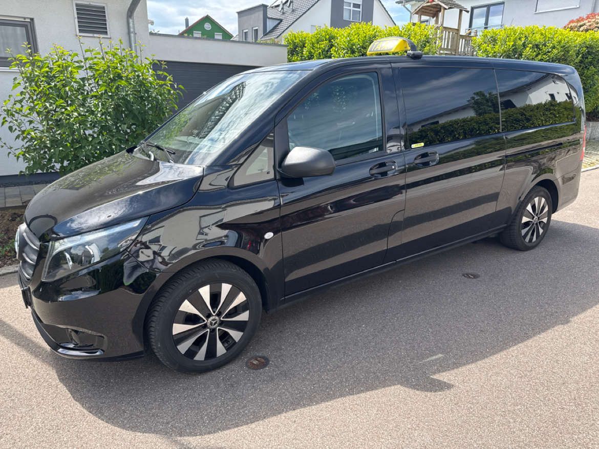 Ein Taxi fährt eine belebte Stadtstraße entlang.