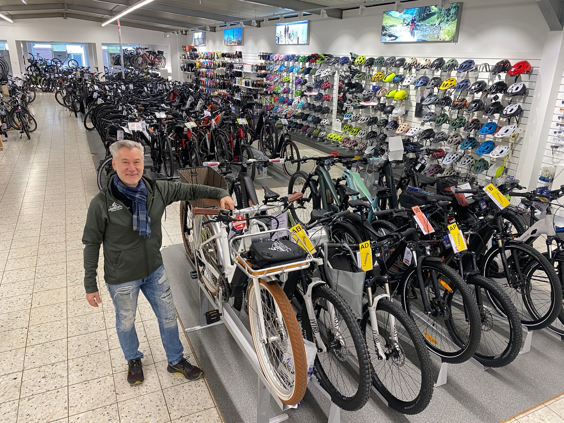 Ein Mann steht in einem Geschäft vor einer Reihe von Fahrrädern.
