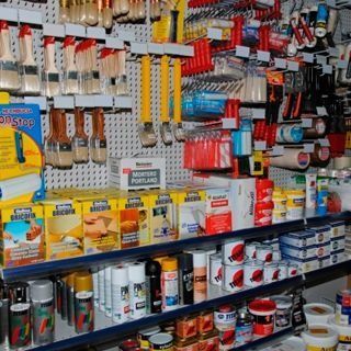 Un montón de pinceles están colgados en la pared de una tienda.
