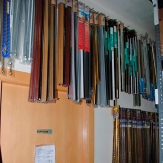 Un montón de cinturones están colgados en la pared de una tienda.