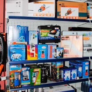 Un estante de tienda lleno de una variedad de artículos, incluida una motosierra.