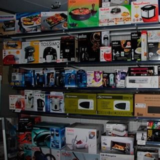 Un estante lleno de electrodomésticos, incluida una cafetera Tossimo.