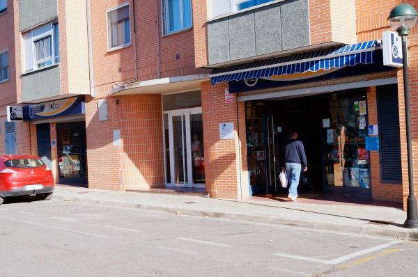 Un coche rojo está aparcado delante de un edificio.