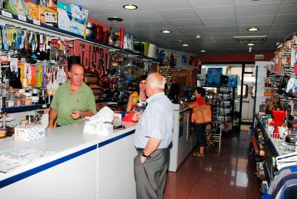 Un hombre con una camisa verde está de pie ante un mostrador en una tienda.