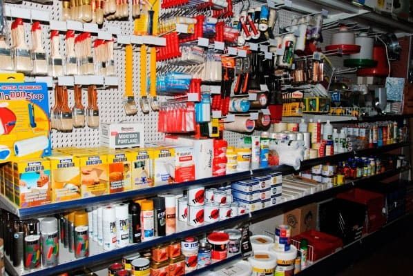 Un estante de una tienda lleno de pinturas y pinceles.