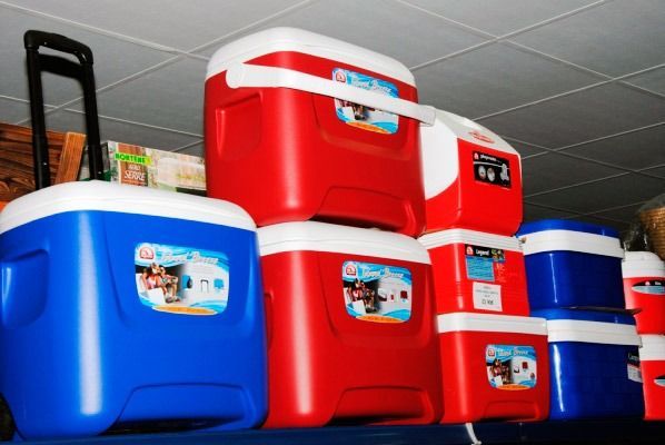 Los refrigeradores rojos y azules están apilados uno encima del otro en un estante.