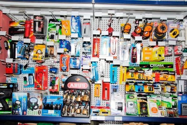 Un montón de herramientas están colgadas en la pared de una tienda.