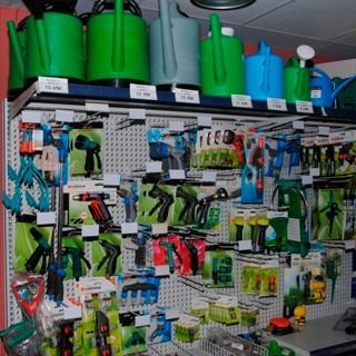 Una exhibición de herramientas de jardinería, incluidas regaderas.