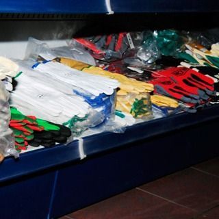 Un montón de guantes de diferentes colores están en un estante.