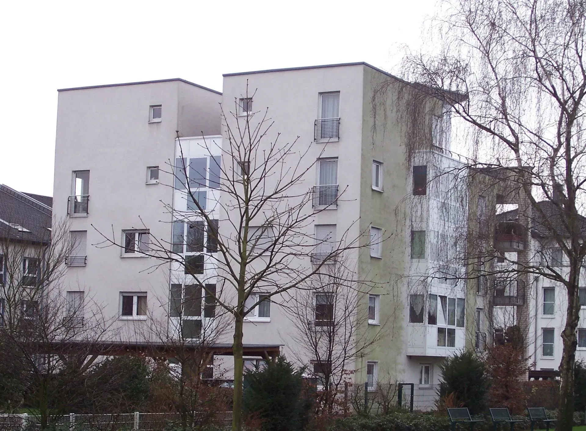 Ein hohes Gebäude mit vielen Wohnungen und Bäumen davor