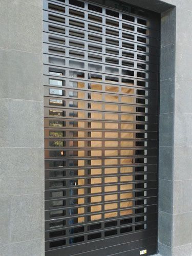 Una persiana enrollable negra en el lateral de un edificio