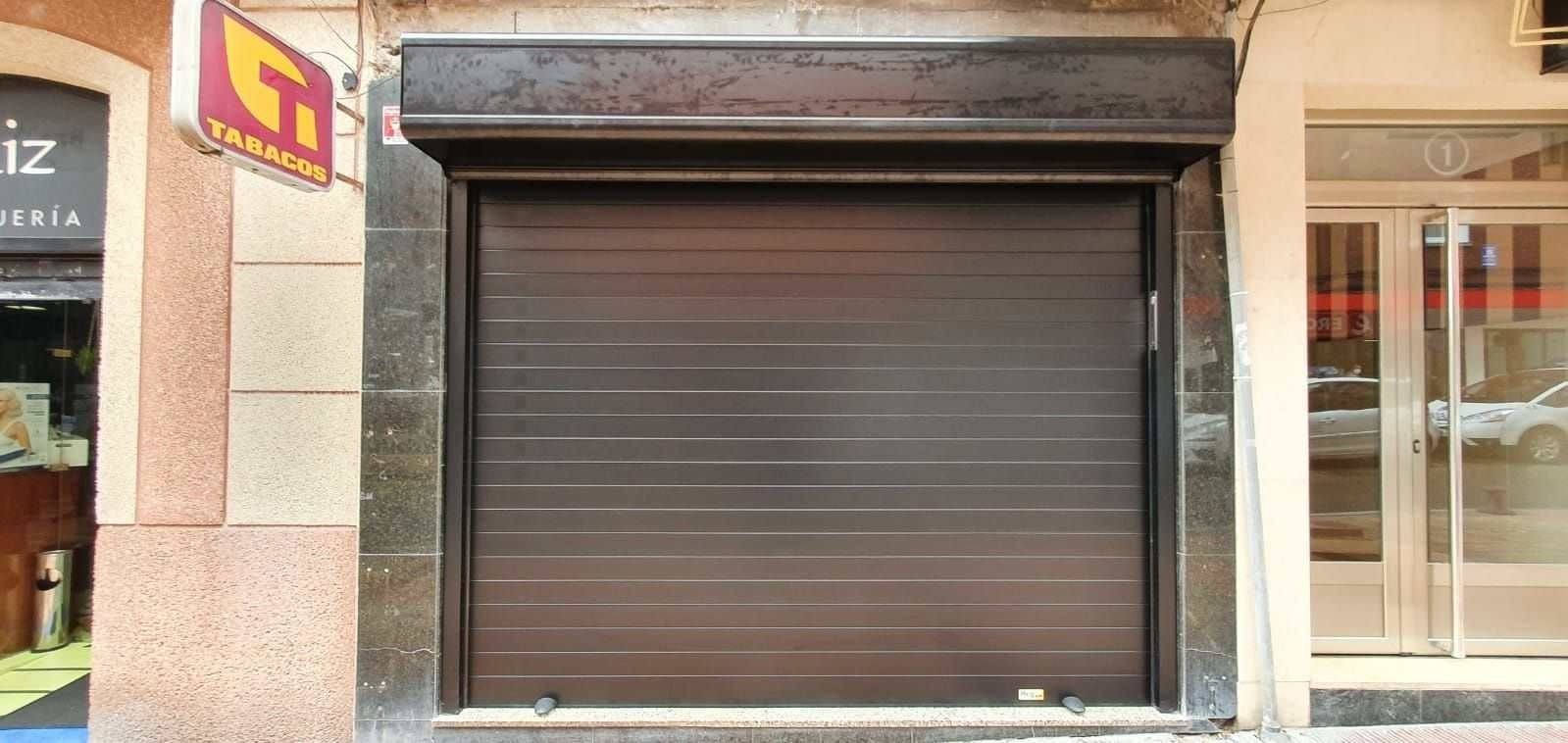 Una tienda vacía con una puerta de garaje marrón.