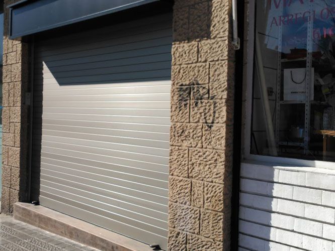 Un frente de tienda con una puerta de garaje y una ventana