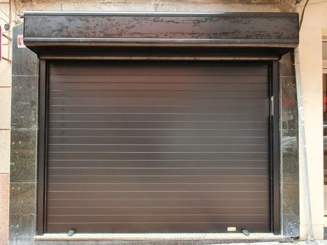 Una puerta de garaje marrón está abierta en el costado de un edificio.