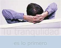 Un hombre está sentado en un escritorio con las manos en la cabeza.