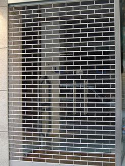 Una pared de ladrillos con una persiana enrollable encima