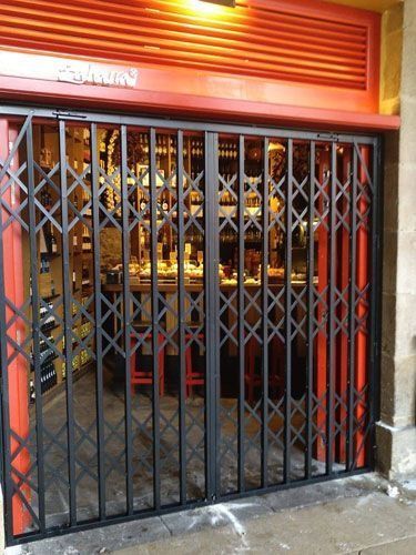 Un restaurante con una puerta roja y un portón negro.
