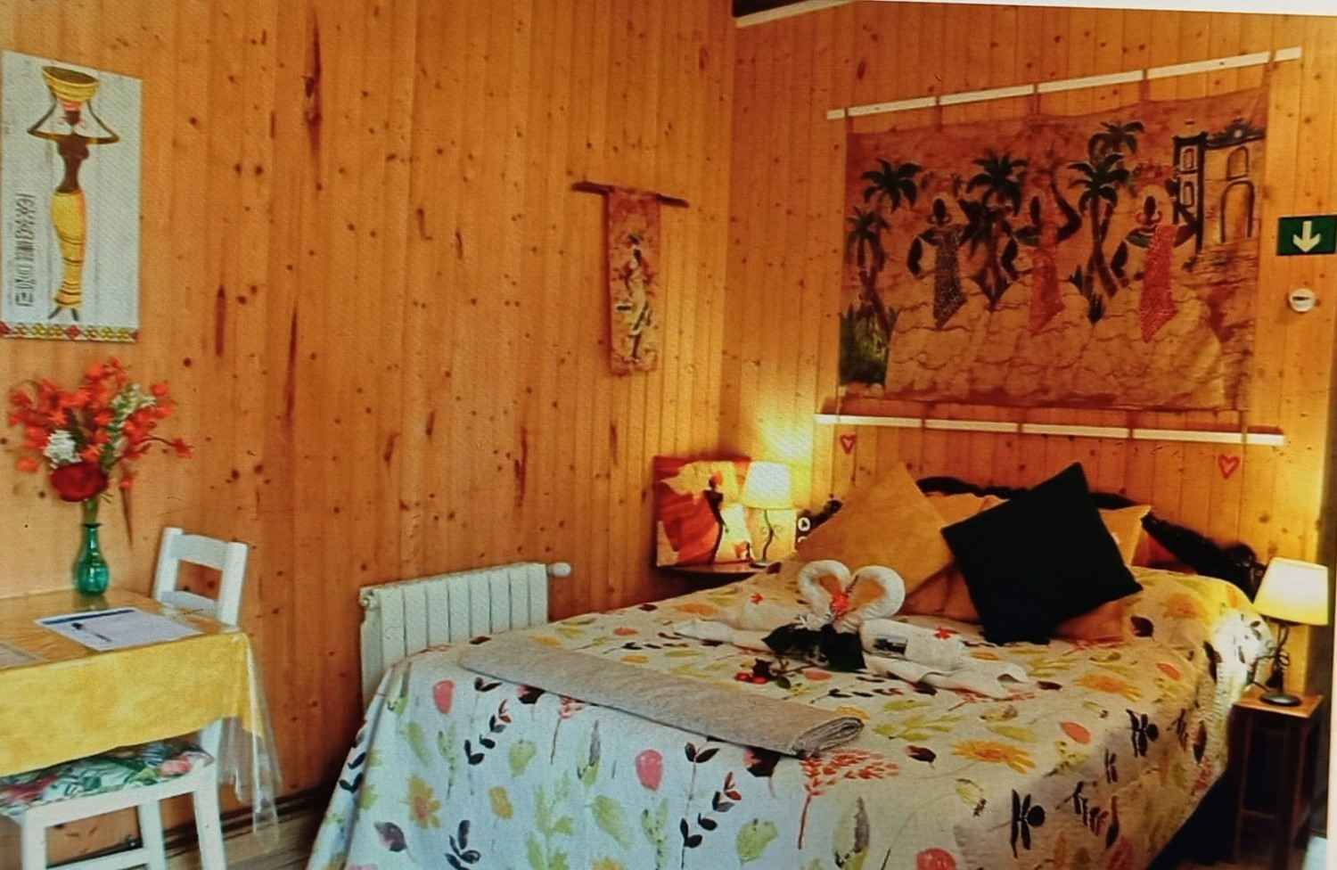 Acogedor dormitorio con paredes revestidas de madera, una cama