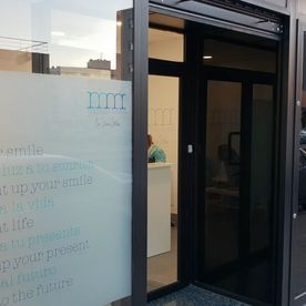 Una puerta de vidrio está abierta a un consultorio dental.