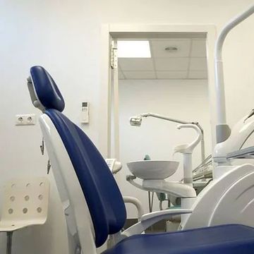 Un sillón dental azul y blanco en un consultorio dental.