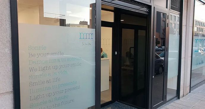 Una tienda con una puerta de vidrio y un cartel que dice que está abierta.
