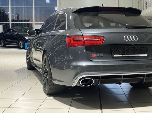 Ein grauer Audi S6 steht in einem Ausstellungsraum.