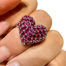Anillo rosa con forma de corazón en un dedo